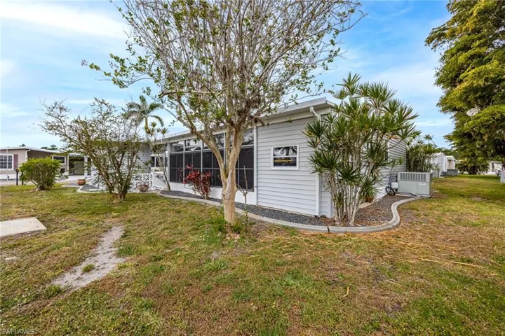 Rear view of house with a yard, cooling unit, and a sunroom