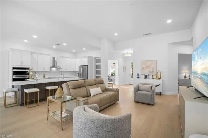 Living area with light wood floors and recessed lighting