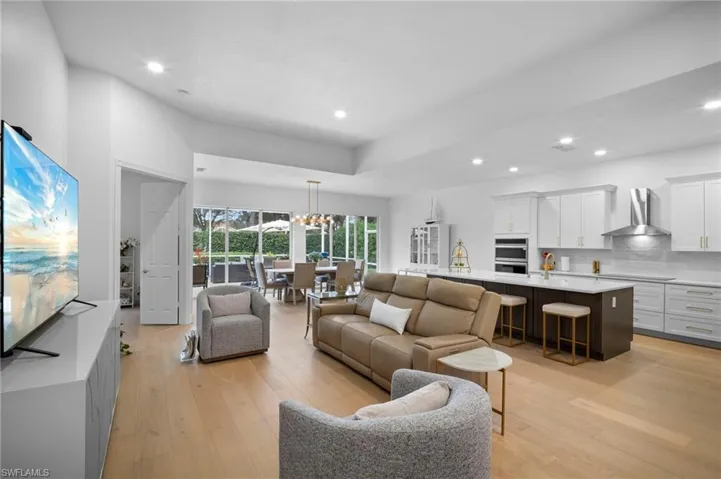 Living area featuring light wood floors, a chandelier, and recessed lighting
