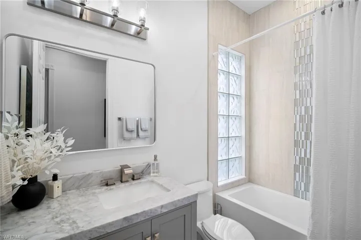 Full bath featuring shower / tub combo with curtain and vanity