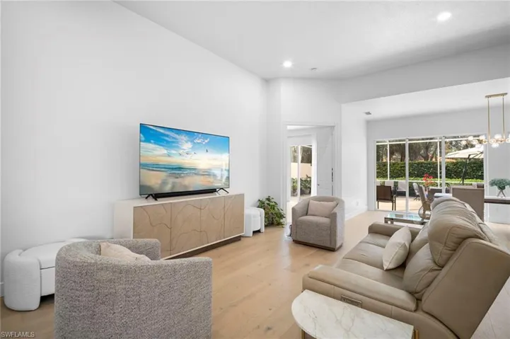Living room featuring wood flooring, a chandelier, and recessed lighting