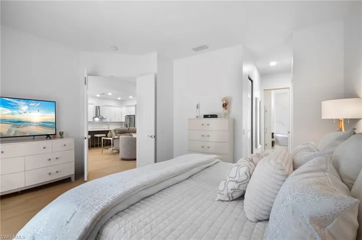 Bedroom featuring light wood floors, access to outside, and lofted ceiling