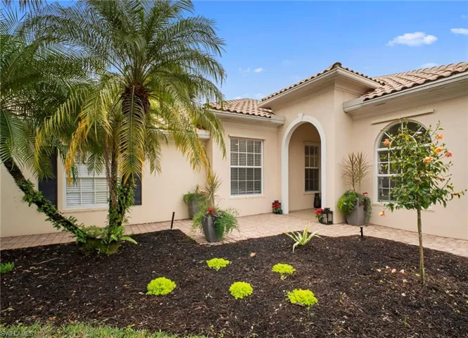View of exterior entry with stucco siding and a tiled roof