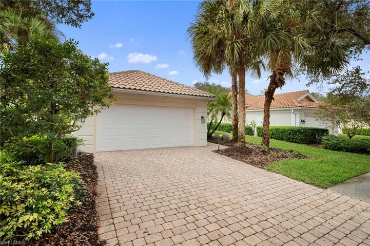 View of front of home with a garage, decorative driveway, a tiled roof, and stucco siding