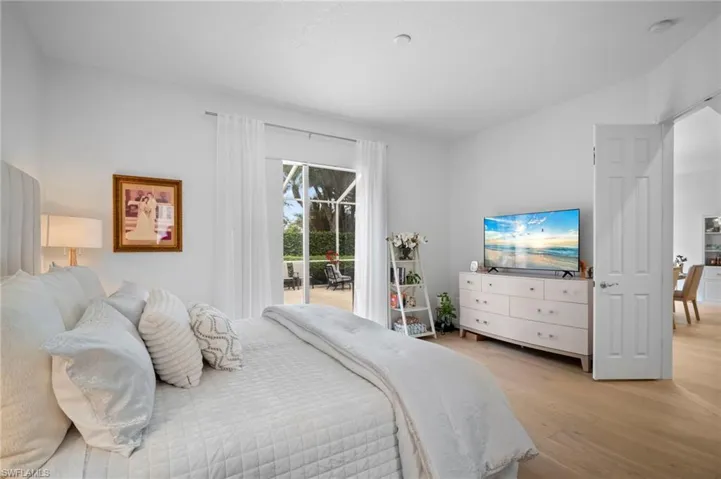 Bedroom featuring light wood floors, access to outside, and lofted ceiling