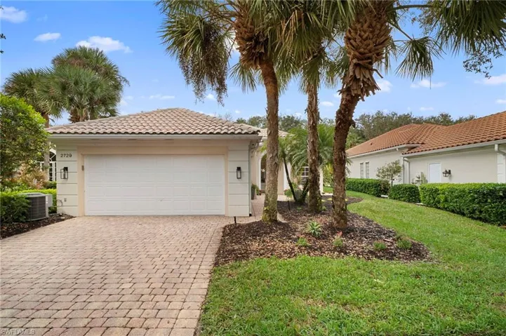 Mediterranean / spanish house with a tile roof, a garage, a front lawn, decorative driveway, and stucco siding