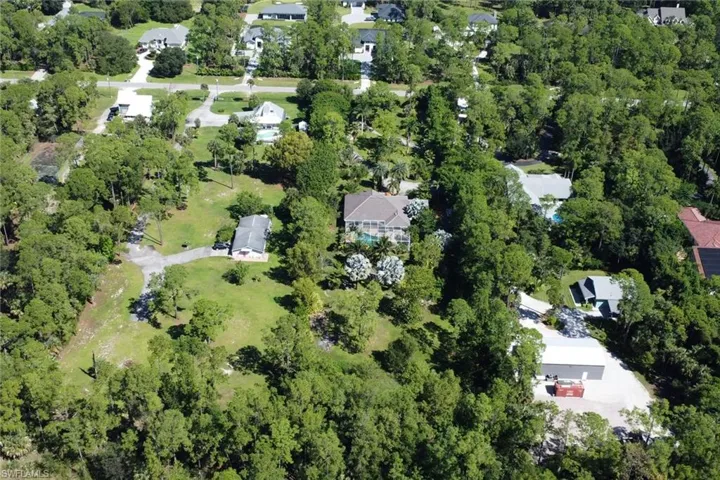 Aerial view of property and surrounding area with nearby suburban area