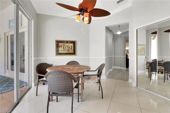 Dining area featuring ceiling fan, crown molding, and light tile patterned floors