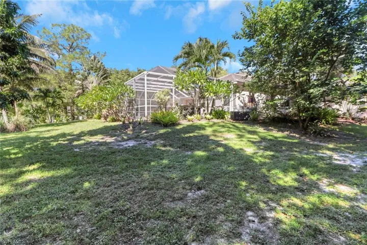 View of green lawn featuring a lanai and a sunroom