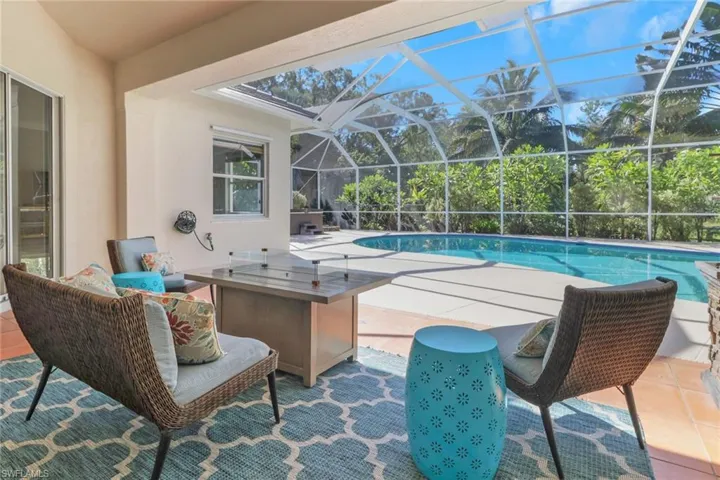 Outdoor pool with a patio area, a sunroom, and glass enclosure