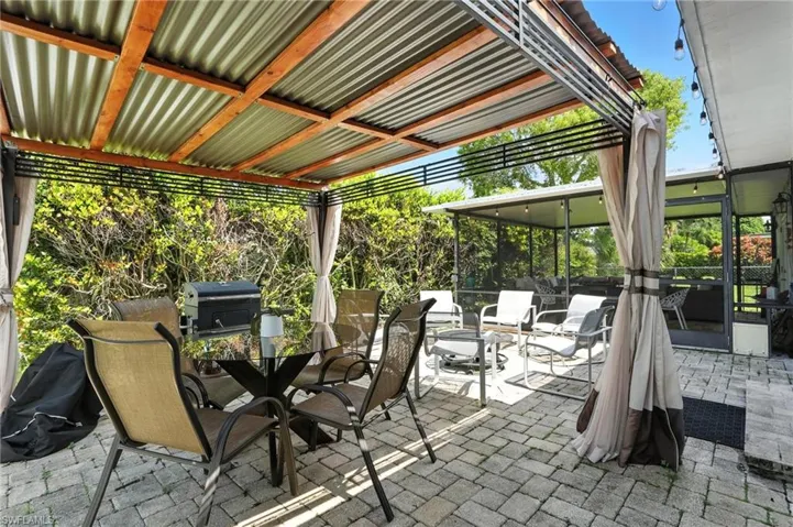 View of patio with outdoor dining area and area for grilling