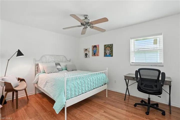 Bedroom featuring ceiling fan, light wood-style floors, and a desk