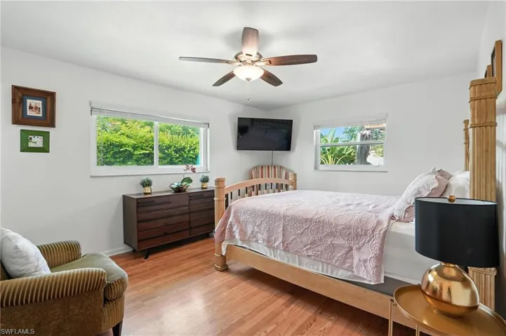 Bedroom featuring multiple windows, wood finished floors, and ceiling fan