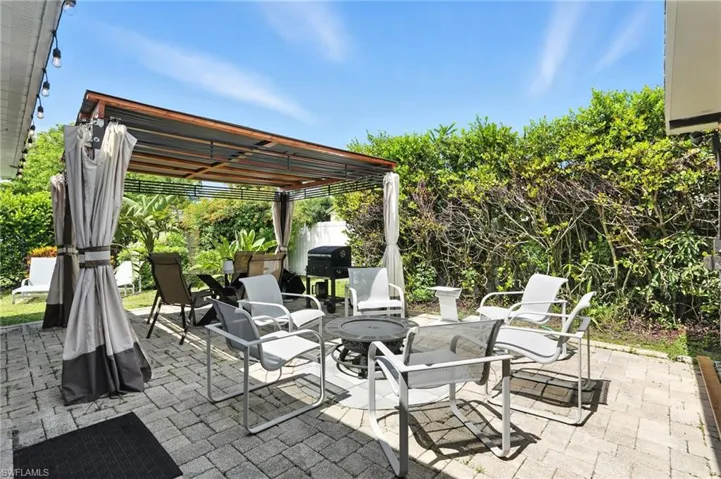 View of patio with a fire pit, area for grilling, and outdoor dining area