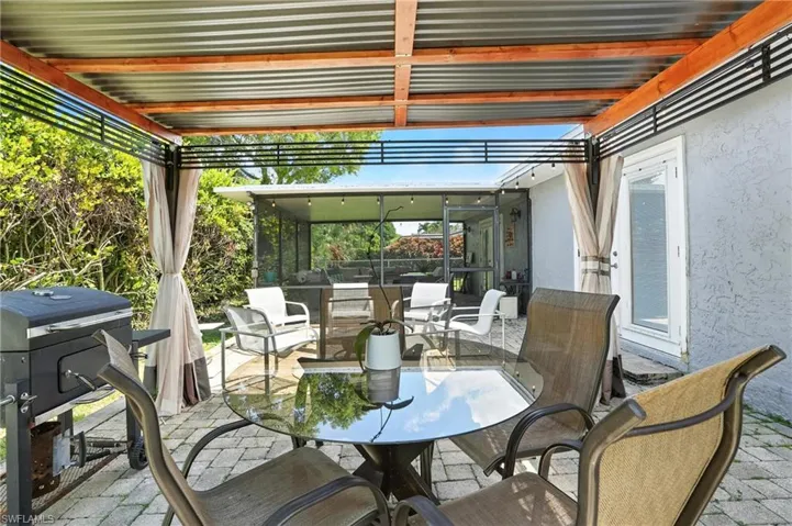View of patio / terrace featuring outdoor dining space and a sunroom