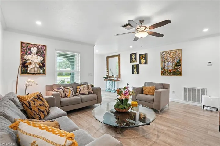 Living area featuring ornamental molding, wood finished floors, a ceiling fan, and recessed lighting