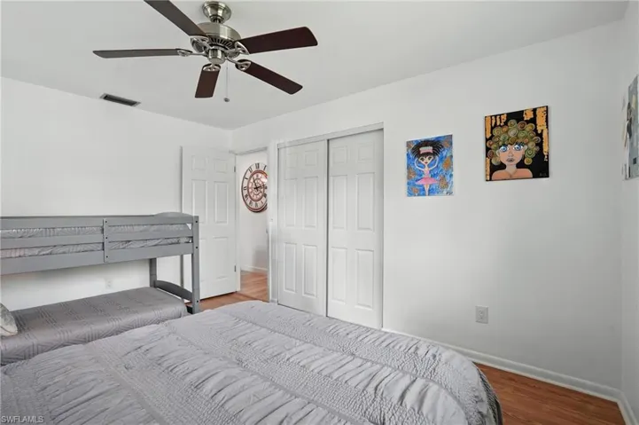 Bedroom featuring wood finished floors, ceiling fan, and a closet