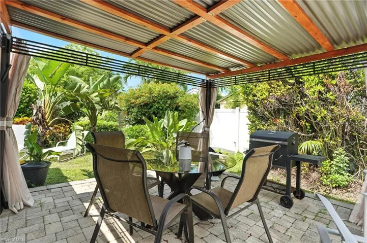 Private backyard with outdoor dining area and a grill