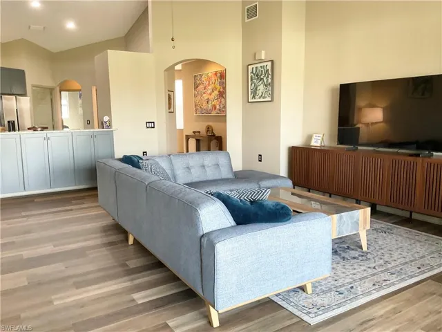 Living room with high vaulted ceiling and large screen smart TV