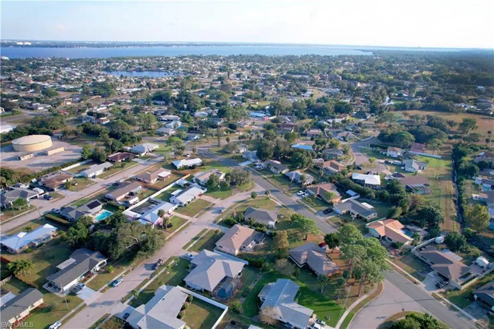Aerial view of property and surrounding area with nearby suburban area