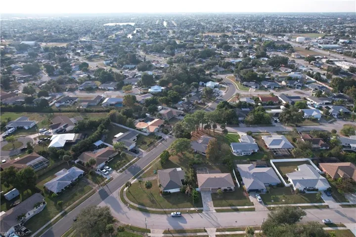 Aerial view of property and surrounding area featuring nearby suburban area