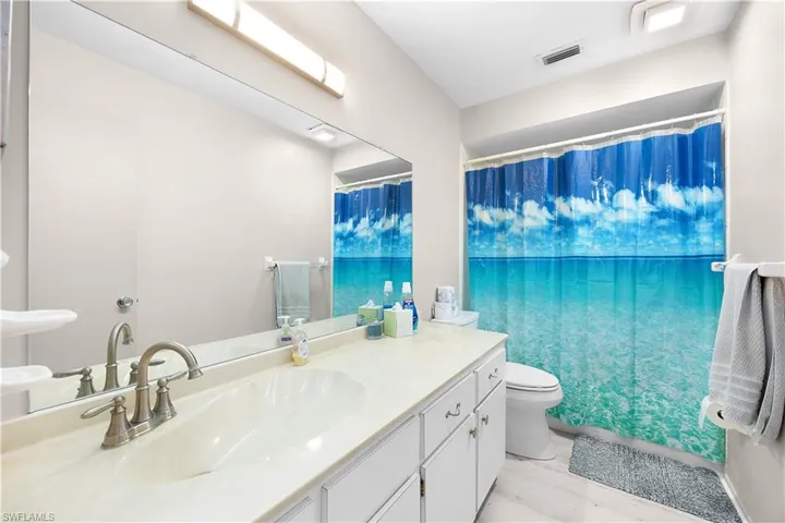 Full bathroom featuring a shower with shower curtain, vanity, and light wood finished floors
