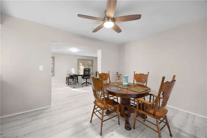 Dining room with a desk, light wood-style floors, and ceiling fan