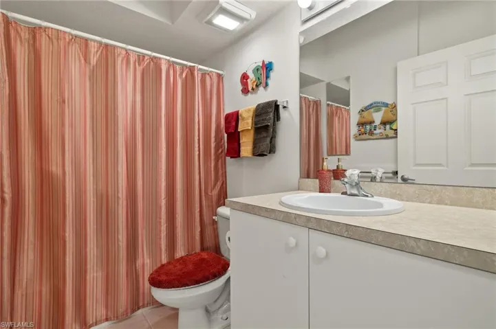Bathroom with vanity, toilet, and tile patterned flooring