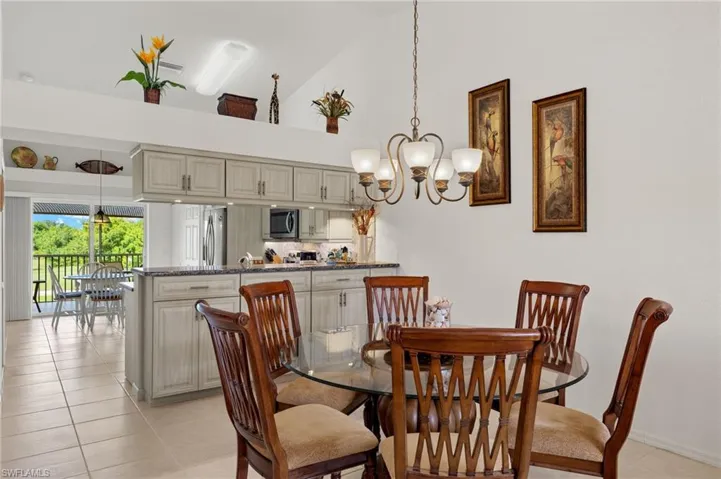 Tiled dining space with high vaulted ceiling and a chandelier