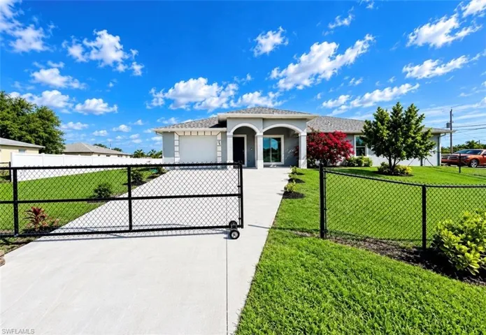 Contemporary single-story residence with a stucco exterior, an attached garage, and an arched entry
