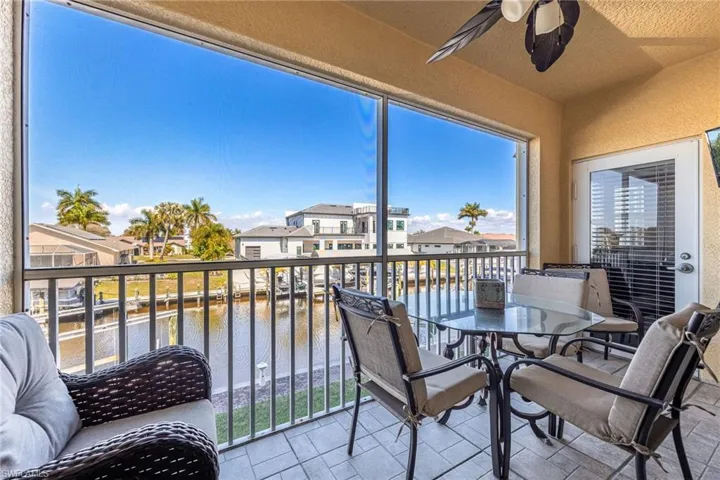 Sunroom with a residential view and a water view