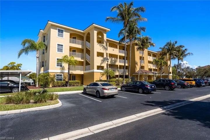 View of apartment building / complex with uncovered parking
