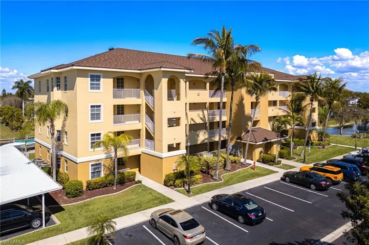 View of apartment building / complex with uncovered parking and a water view
