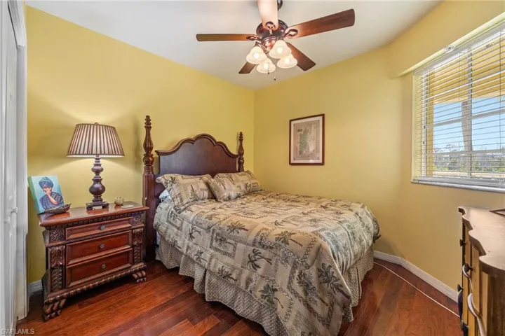 Bedroom with dark wood-style floors, a ceiling fan, and a closet