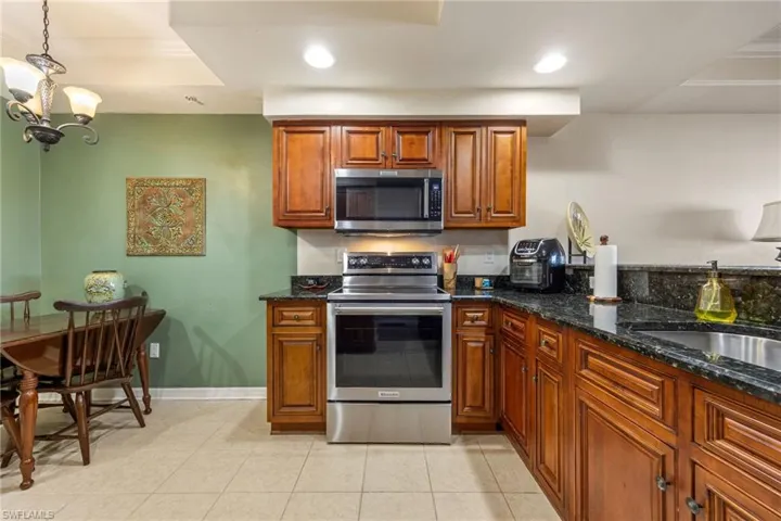 Kitchen featuring wood finish cabinets, dark stone counters, and stainless steel appliances