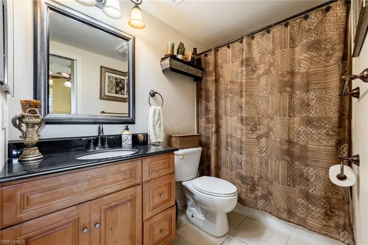 Bathroom featuring vanity, light tile patterned flooring, and a shower with curtain