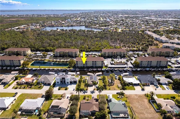 Aerial view of property and surrounding area featuring a large body of water and nearby suburban area