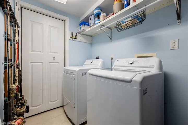 Laundry area featuring washing machine and dryer and light tile patterned flooring