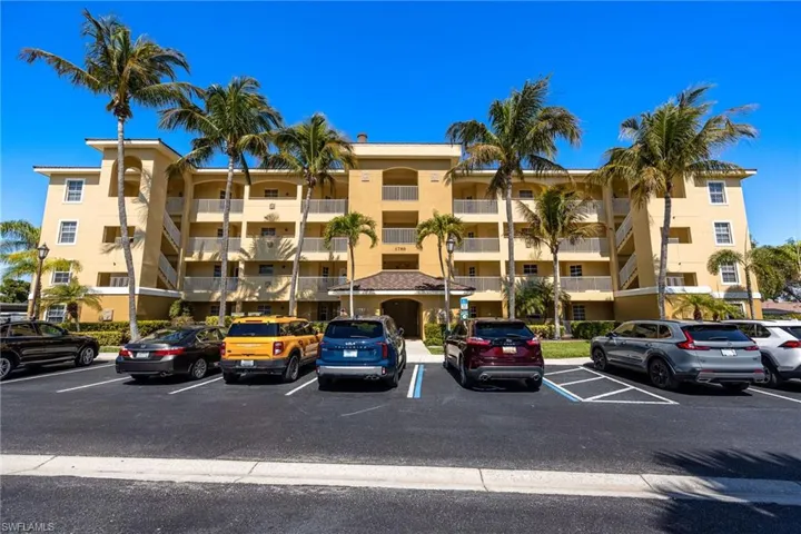 View of apartment building / complex featuring uncovered parking