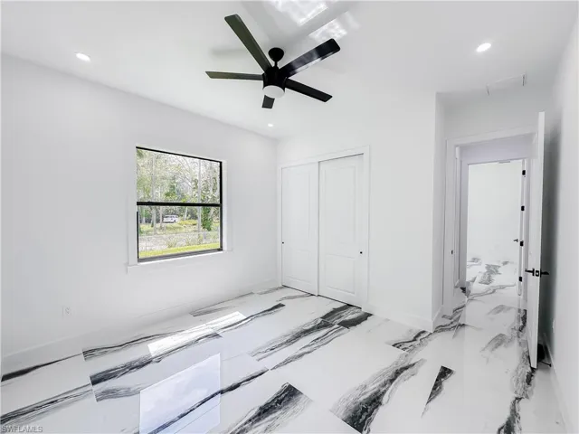 Bedroom with a closet, ceiling fan, and light tile floors