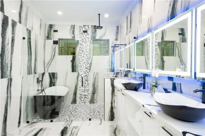 Bathroom with double vanity and tile walls