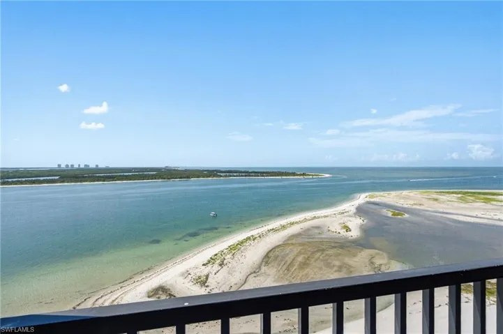 Expansive waterway and coastline views from a private balcony with metal railing - Virtually Edited Image