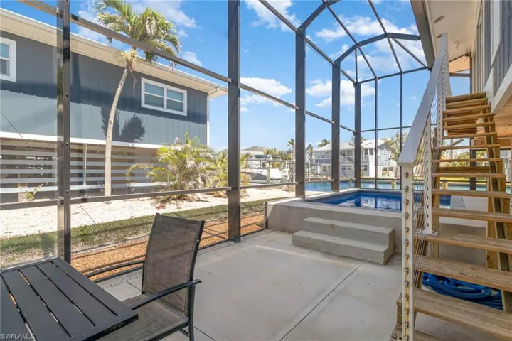 View of patio / terrace with a sunroom, a lanai, an outdoor pool, and stairway
