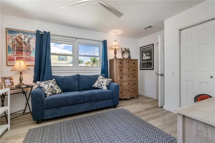 Living room with light wood-style flooring and a ceiling fan