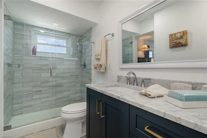 Full bath featuring vanity and a shower stall