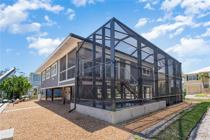 Back of property with a lanai and a sunroom