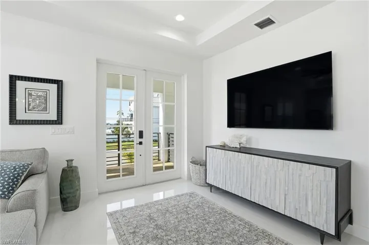 Living area with french doors, light marble finish floors, and recessed lighting