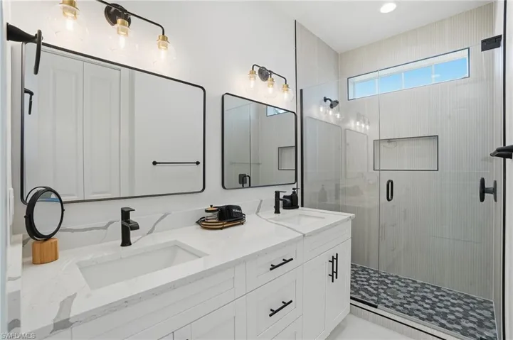 Bathroom featuring double vanity and a stall shower