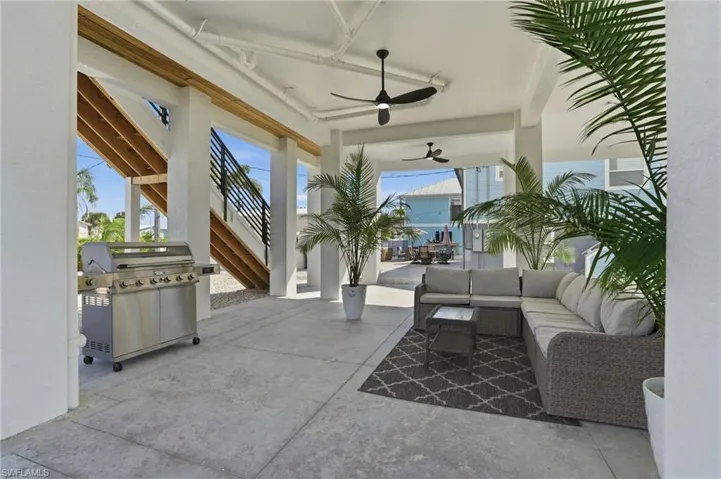 View of patio with stairway, a ceiling fan, a grill, and an outdoor living space