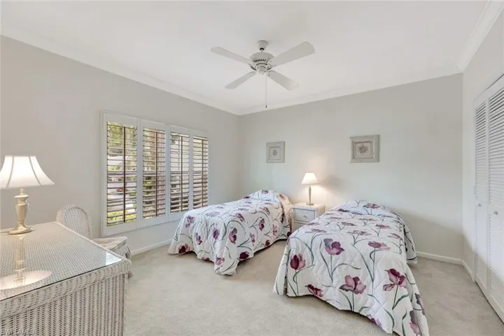 Bedroom with carpet floors, ornamental molding, baseboards, and a closet